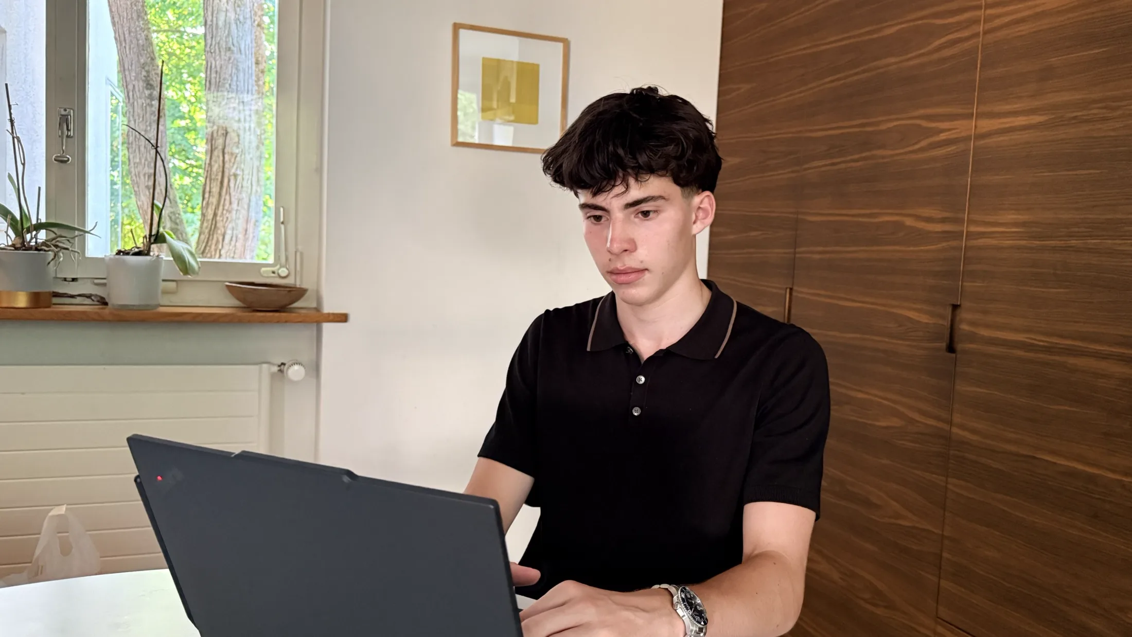 Émery Sartorius arbeitet am Laptop an einer Website